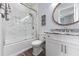 Bright bathroom features a marble lined shower, a round mirror, and white cabinets at 371 12Th Ave, Indian Rocks Beach, FL 33785