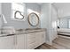 Bright bathroom features a marble countertop, round mirror, and white cabinets at 371 12Th Ave, Indian Rocks Beach, FL 33785