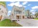 Charming light blue home with well-maintained lawn, complemented by a paved driveway and a golf cart at 371 12Th Ave, Indian Rocks Beach, FL 33785