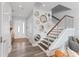 Bright foyer boasting decorative mirrors and staircase with wooden treads and metal railing at 371 12Th Ave, Indian Rocks Beach, FL 33785