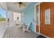 Charming front porch features seating and brown front door of blue home at 371 12Th Ave, Indian Rocks Beach, FL 33785