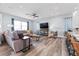 Bright living room with gray seating, wood floors, recessed lighting, and open-concept view to kitchen at 371 12Th Ave, Indian Rocks Beach, FL 33785