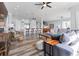 Open-concept living room includes island with bar seating, sofas, ceiling fans, and hardwood floors at 371 12Th Ave, Indian Rocks Beach, FL 33785
