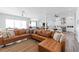 Open-concept living room with tan leather sofa, wood floors, and views into kitchen with stainless appliances at 371 12Th Ave, Indian Rocks Beach, FL 33785