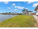 Expansive backyard with a well-manicured lawn, gazebo, and canal views under a partly cloudy sky at 4331 13Th Ne Way, St Petersburg, FL 33703