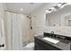 Bathroom featuring stone tile, a black granite sink, and a shower with decorative shower curtain at 4331 13Th Ne Way, St Petersburg, FL 33703