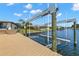 This waterfront home features a boat lift leading up to the house under a partly cloudy sky at 4331 13Th Ne Way, St Petersburg, FL 33703