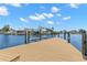 Waterfront home featuring a dock with boat lift and stunning blue water views under a partly cloudy sky at 4331 13Th Ne Way, St Petersburg, FL 33703