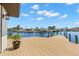 Waterfront home featuring a large wooden dock with boat lift and beautiful water views under a partly cloudy sky at 4331 13Th Ne Way, St Petersburg, FL 33703