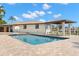 Beautiful pool with a brick patio, home, and canal in the background under a partly cloudy sky at 4331 13Th Ne Way, St Petersburg, FL 33703