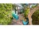 Cozy outdoor patio area with blue chairs, lush greenery, and unique decorative accents at 4570 Overlook Ne Dr # 180, St Petersburg, FL 33703