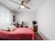 Bedroom features a ceiling fan, a desk, and a comfortable bed with a red coverlet at 460 4Th S St, Safety Harbor, FL 34695
