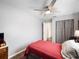 Relaxing bedroom features a red bedspread, a closet, and hardwood floors at 460 4Th S St, Safety Harbor, FL 34695