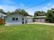 Single-story home with manicured lawn and a driveway leading to an attached garage at 460 4Th S St, Safety Harbor, FL 34695