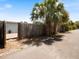 Property showing a wooden fence lined with palm trees and a glimpse of a home's exterior wall at 460 4Th S St, Safety Harbor, FL 34695