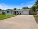 Inviting single-story home with light blue walls, white brick accents, and an expansive driveway at 460 4Th S St, Safety Harbor, FL 34695