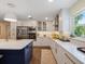 Bright kitchen with stainless steel appliances, white cabinets, and a large island at 460 4Th S St, Safety Harbor, FL 34695