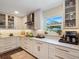 Bright kitchen with stylish white cabinets, marble countertops, and a garden view from the window at 460 4Th S St, Safety Harbor, FL 34695