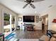 Bright living area boasts a large TV, sliding glass door to the backyard, and wood floors at 460 4Th S St, Safety Harbor, FL 34695
