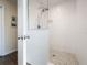 Bright, updated shower with white tile and pebble flooring, with clear glass shower door at 460 4Th S St, Safety Harbor, FL 34695