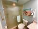 Bathroom featuring a glass shower, tile flooring, neutral countertop, and beach-themed decor at 4740 Carrington Ct # 4740, New Port Richey, FL 34655