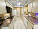 Efficient galley kitchen features white appliances, white cabinetry and ample countertop space at 4740 Carrington Ct # 4740, New Port Richey, FL 34655