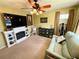 Cozy living room with a fireplace, ceiling fan, comfortable couch, and stylish decor at 4740 Carrington Ct # 4740, New Port Richey, FL 34655
