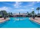 Large community pool area under a bright blue sky with palm trees around the edges at 5225 Coquina Key Se Dr # B, St Petersburg, FL 33705