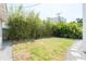 Landscaped backyard featuring green grass, stone pavers, and mature foliage at 53 Albemarle Ave, Tampa, FL 33606