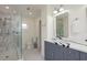 Bathroom featuring double sinks, marble countertops, a glass shower, and mosaic tile flooring at 53 Albemarle Ave, Tampa, FL 33606