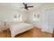 Bright bedroom featuring hardwood floors, a ceiling fan, and two windows for natural light at 53 Albemarle Ave, Tampa, FL 33606