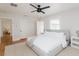 Bright, minimalist bedroom featuring white bedding, light gray accents, and wood flooring at 53 Albemarle Ave, Tampa, FL 33606