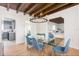 Open dining room with exposed wood beams, glass table and view into the kitchen and living room at 53 Albemarle Ave, Tampa, FL 33606
