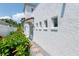 Home exterior with white stucco and dark trim and a side yard with flowers at 53 Albemarle Ave, Tampa, FL 33606