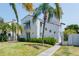 Elegant two-story white home with a red tile roof, complemented by lush greenery and a charming arched entrance at 53 Albemarle Ave, Tampa, FL 33606