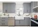 Modern kitchen featuring sleek gray cabinets, a farmhouse sink, and stainless steel appliances at 53 Albemarle Ave, Tampa, FL 33606