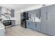 Bright kitchen boasts modern appliances, gray cabinetry, and eye-catching marble backsplash complemented by wood flooring at 53 Albemarle Ave, Tampa, FL 33606