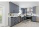 Well-lit kitchen featuring gray cabinets, stainless steel appliances, and marble-style backsplash and countertops at 53 Albemarle Ave, Tampa, FL 33606