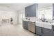 Stylish kitchen with gray cabinets, stainless steel dishwasher, and white farmhouse sink with elegant faucet fixtures at 53 Albemarle Ave, Tampa, FL 33606