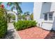 Cozy brick patio with garden, archway, and view of the neighborhood, perfect for outdoor relaxation at 53 Albemarle Ave, Tampa, FL 33606