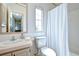 Cozy bathroom featuring patterned wallpaper, a shower with curtain, and a practical vanity at 5721 Apache St, Zephyrhills, FL 33542
