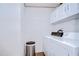 Functional laundry room with a washer, dryer, cabinets, and neutral decor at 5721 Apache St, Zephyrhills, FL 33542