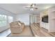Bright living room featuring wood-look floors, neutral walls, and a plush sofa at 5721 Apache St, Zephyrhills, FL 33542