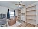Comfortable living room featuring hardwood floors, built-in shelving, and an inviting armchair at 5721 Apache St, Zephyrhills, FL 33542