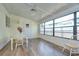 Inviting sunroom with wood floors, bright windows, and a charming dining set at 5721 Apache St, Zephyrhills, FL 33542