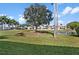 Expansive backyard view showcasing lush green grass, palm trees, a pond, and surrounding buildings at 6085 Bahia Del Mar Blvd # 106, St Petersburg, FL 33715