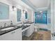 Updated bathroom featuring dual sinks, granite countertops, and a tiled walk-in shower at 6085 Bahia Del Mar Blvd # 106, St Petersburg, FL 33715