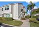Two-story condo with a red tile roof, lush landscaping, and well-maintained sidewalk leading to the entrance at 6085 Bahia Del Mar Blvd # 106, St Petersburg, FL 33715