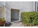 Inviting entryway with a modern glass door, tiled landing, and a vibrant welcome mat, framed by lush landscaping at 6085 Bahia Del Mar Blvd # 106, St Petersburg, FL 33715