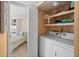 Functional laundry area equipped with modern washer and dryer units, and shelving for organized storage at 6085 Bahia Del Mar Blvd # 106, St Petersburg, FL 33715
